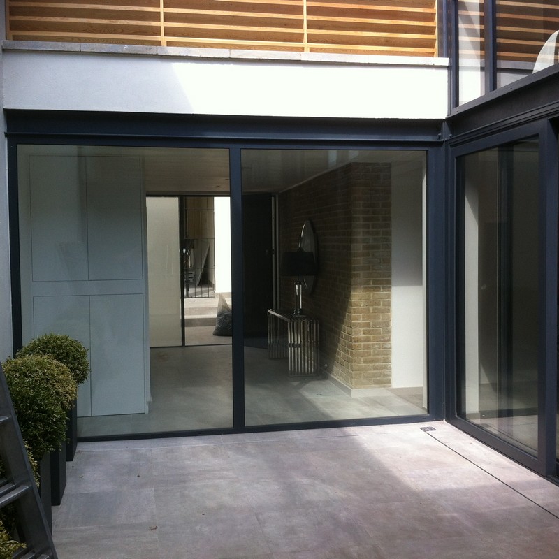 Floor-to-ceiling sliding doors opening to courtyard in West Drayton