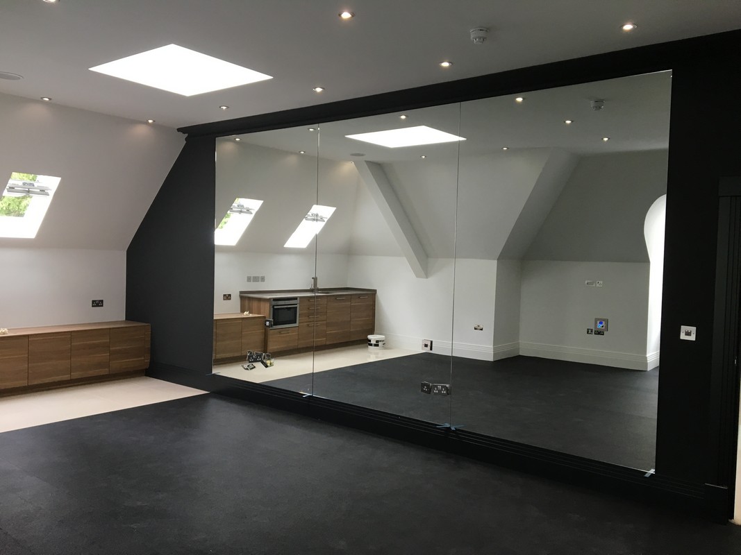 Frameless glass wall dividing loft conversion in West Drayton